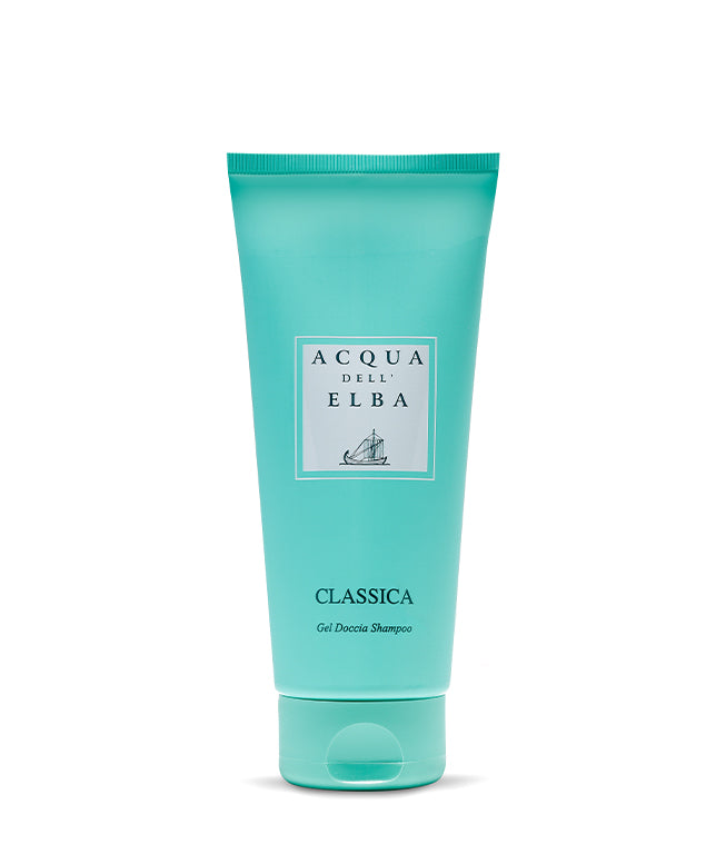 A turquoise tube of Acqua dell’Elba Classica Uomo Body Lotion, adorned with a white label with navy text and a sailboat illustration, stands upright against a plain white background, reflecting its signature marine-inspired elegance.