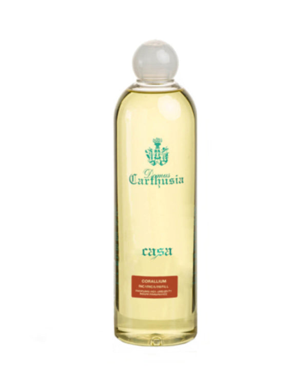 A tall clear bottle with a round glass cap holds yellow liquid. The label reads "Carthusia casa" in green and "Corallium" in red, reflecting the fresh scent of the Carthusia Corralium Reed Diffuser Refill - 500ml by Carthusia I Profumi de Capri.