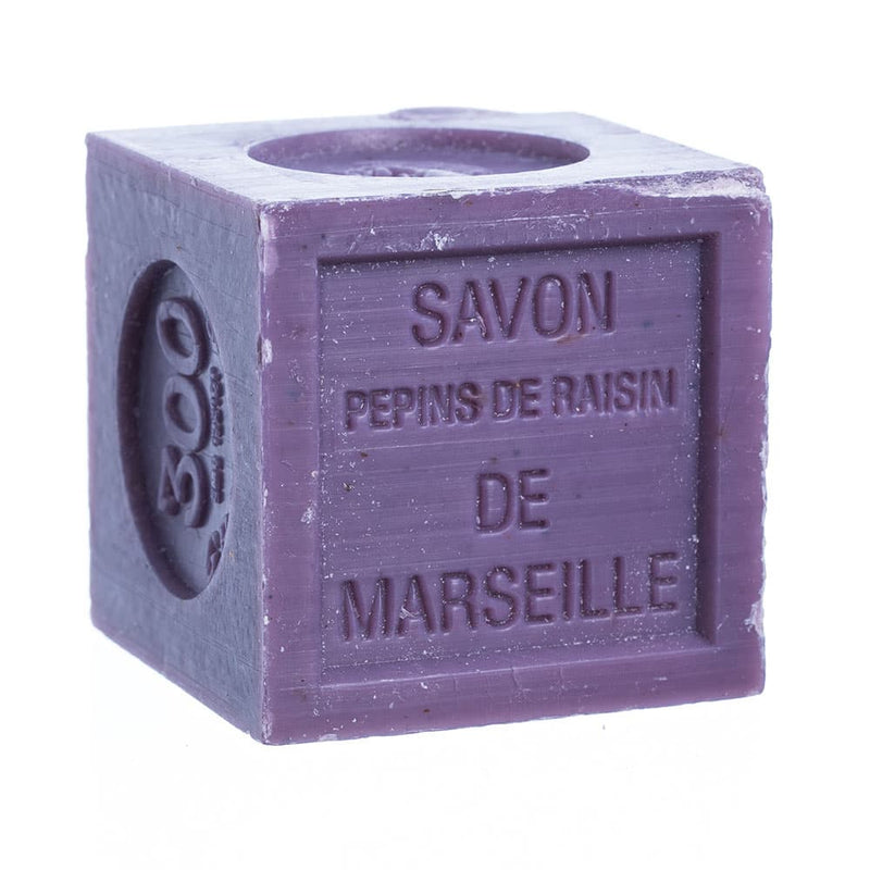 A purple cube-shaped bar of French Soaps Savon de Marseille with Crushed Flowers - Grapevine, designed to exfoliate, isolated on a white background.
