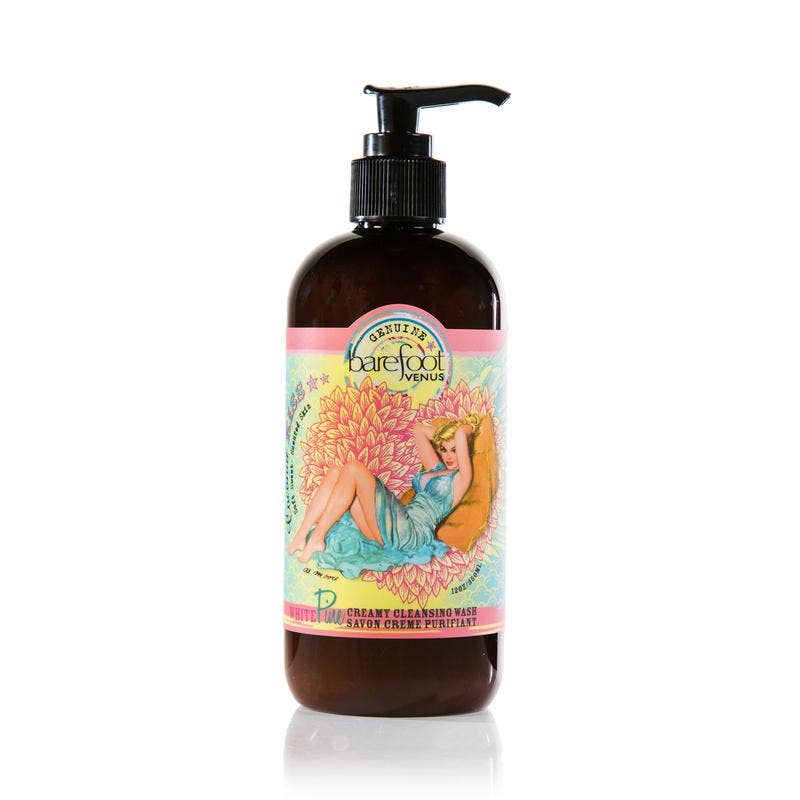 A brown pump bottle labeled "Barefoot Venus Coconut Kiss Cleansing Hand & Body Wash" features an illustration of a woman lounging against a colorful, floral background. The text on the label includes product details for this all-natural plant-derived Cleansing Hand & Body Wash by Barefoot Venus.