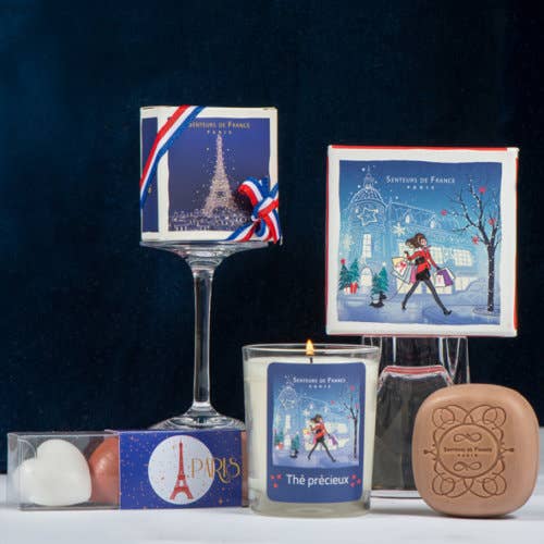 A French-themed gift set featuring a decorated wine glass, scented candle, chocolate hearts, and a Senteurs De France Eiffel Tower Amber Scented Soap, all in a Parisian-style gift box with charming designs.