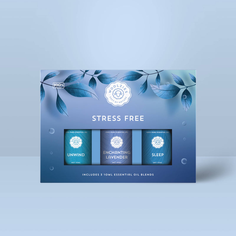 A blue Woolzies Stress Free Collection box with leaf designs holds three 10ml calming oils: Unwind, Enchanting Lavender, and Sleep—Woolzies’ natural relaxation essentials.