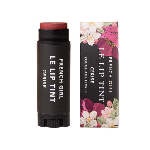 A tube of FRENCH GIRL - Tinted Lip Balm | Cerise rests beside its floral box, both adorned with white text. This vegan balm from FRENCH GIRL provides a hydrating treatment and a deep red tint for your lips.