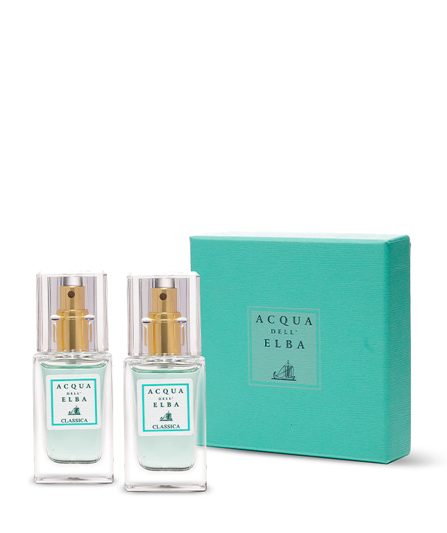 Two bottles of Acqua dell'Elba Classica Donna - Mia Box perfume, each with a gold spray top, are displayed next to a turquoise gift box featuring the Acqua dell’Elba logo and sailboat, reflecting its signature Mediterranean style.