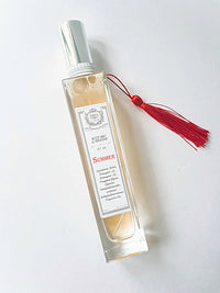A rectangular glass bottle from Z&Co. Farmhouse Collection Body Mist Perfumes features a silver cap, red tassel, and elegant "Summer" label—perfect for holding your favorite Z&Co. long-lasting scent or body mist.