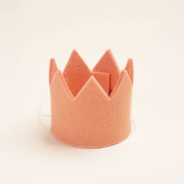 The MODERNBEAST Wool Pet Party Crown by MODERNBEAST is a small, soft pink felt crown with pointed tips, shaped in a circle for pets to wear, pictured on a light neutral background.