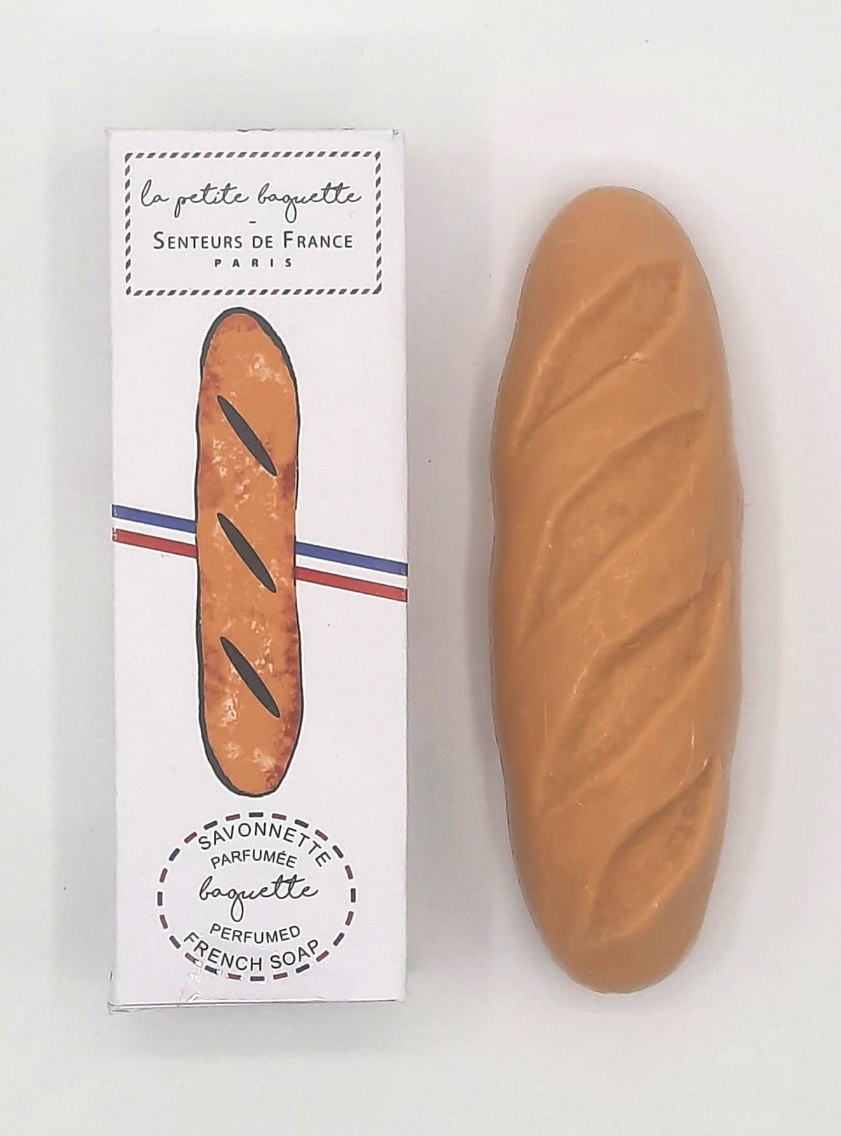 Senteurs De France’s "Baguette" Soap is shown beside its packaging, which displays a baguette illustration and French text “la petite baguette” and “savonnette parfumée”—a charming French heritage keepsake.