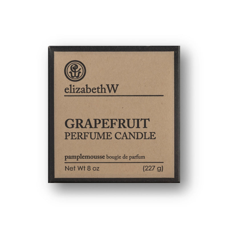 A square, brown cardboard box with black text that reads "elizabeth W Purely Essential Grapefruit Candle pamplemousse bougie de parfum Net Wt 8 oz (227 g)." The soy wax candle boasts a long-lasting fragrance. The box has a black border and features a minimal design with a logo at the top.