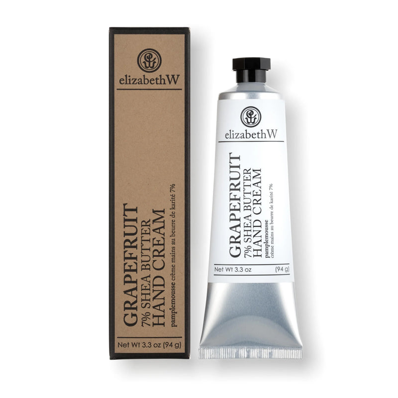 A tube of elizabeth W Purely Essential Grapefruit Hand Cream with shea butter next to its packaging box. The tube is silver with a black cap, and the box is brown with black and white labels.