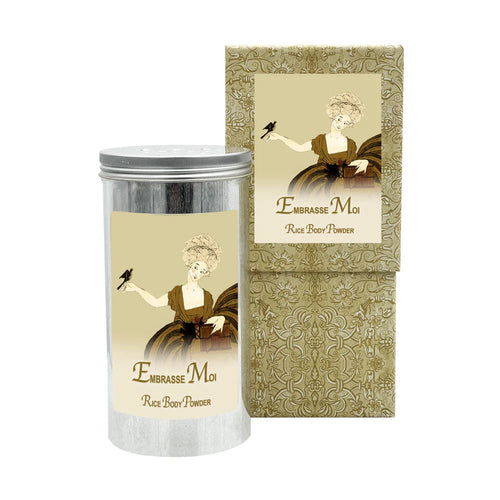 The La Bouquetiere Embrasse Moi Rice Body Powder Canister has a silver cylinder container with a vintage-style illustration of a person in a dress holding a bird. The packaging, infused with natural fragrances, showcases an ornate, sepia-toned design.