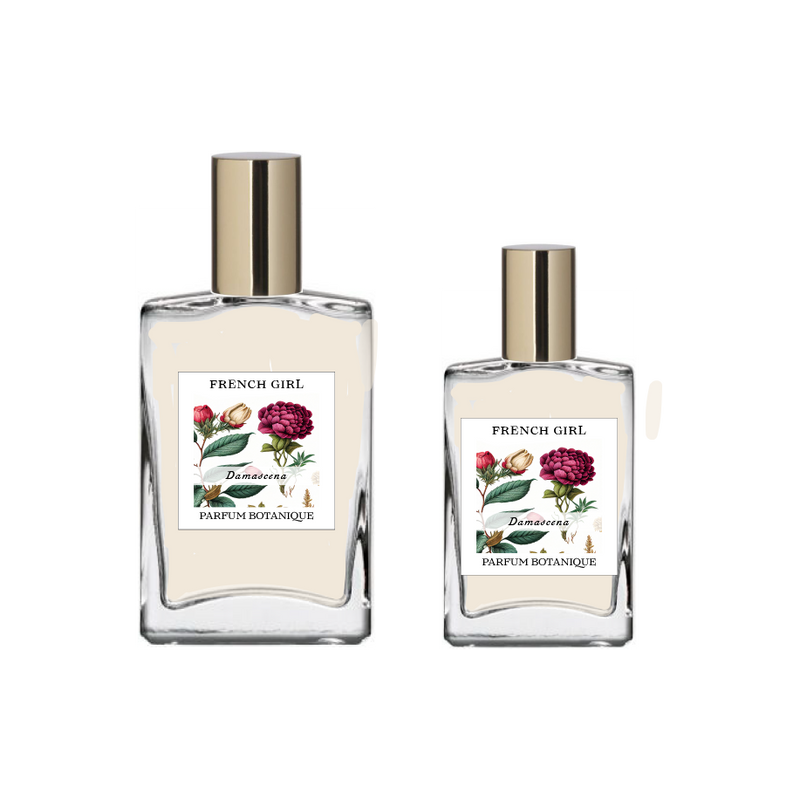 Two clear glass bottles with gold caps, labeled "FRENCH GIRL Damascena Rose Organic Vegan Natural Aromatherapy Perfume," each adorned with floral designs. These luxurious, alcohol-free perfumes are crafted with natural essential oils.