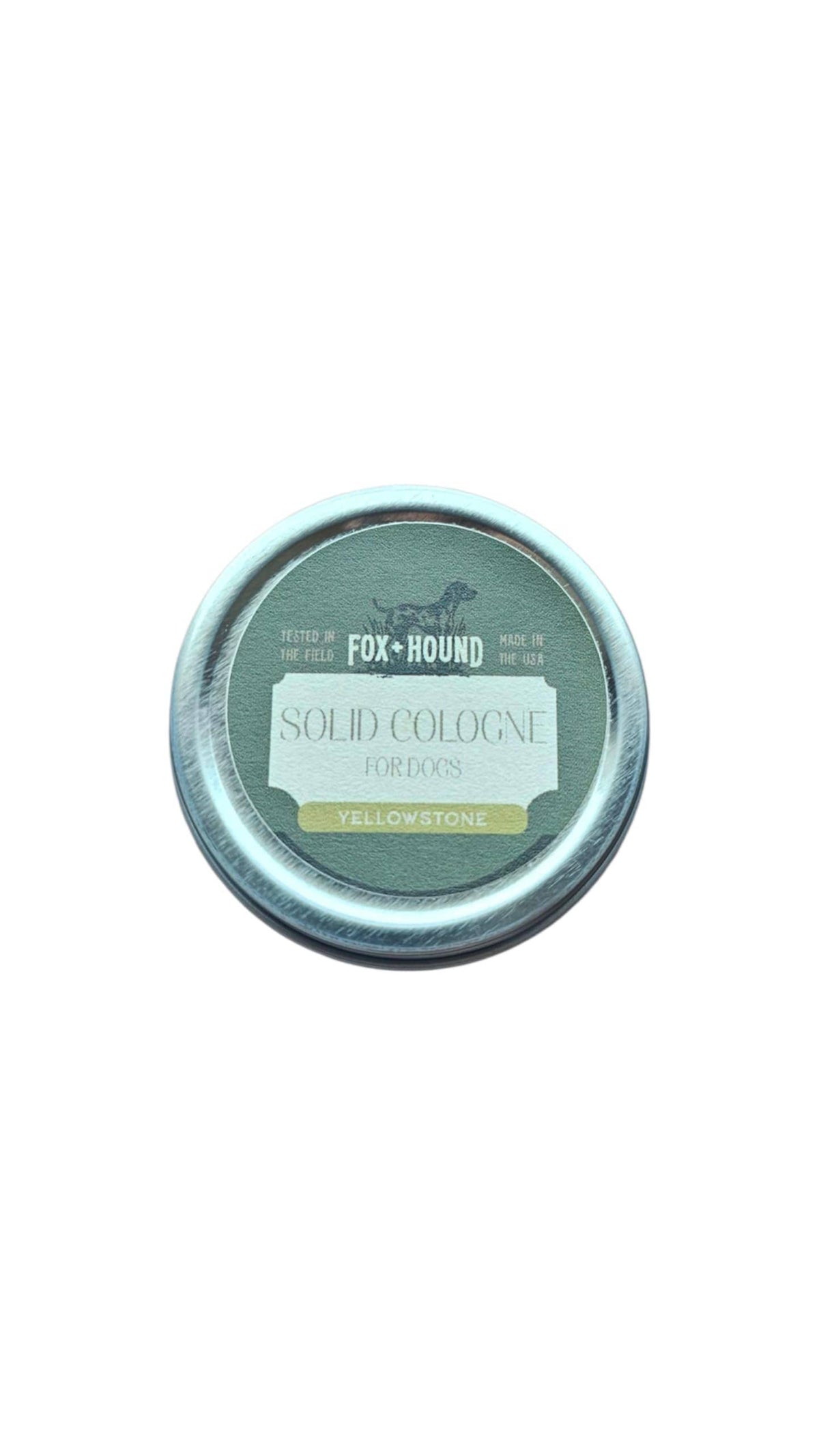 The Fox + Hound Yellowstone Solid Dog Cologne by Fox + Hound comes in a round tin with green and yellow accents, is field-tested, made in the USA, and is ideal for traveling with your dog.