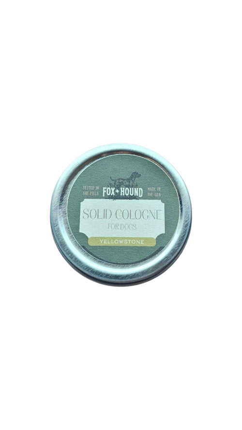 The Fox + Hound Yellowstone Solid Dog Cologne by Fox + Hound comes in a round tin with green and yellow accents, is field-tested, made in the USA, and is ideal for traveling with your dog.
