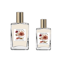 Two glass bottles of FRENCH GIRL Attara Organic Vegan Amber Natural Aromatherapy Perfume, each with a gold cap and large brownish-red flower illustration, are available in different sizes and contain alcohol-free, vegan fragrance.