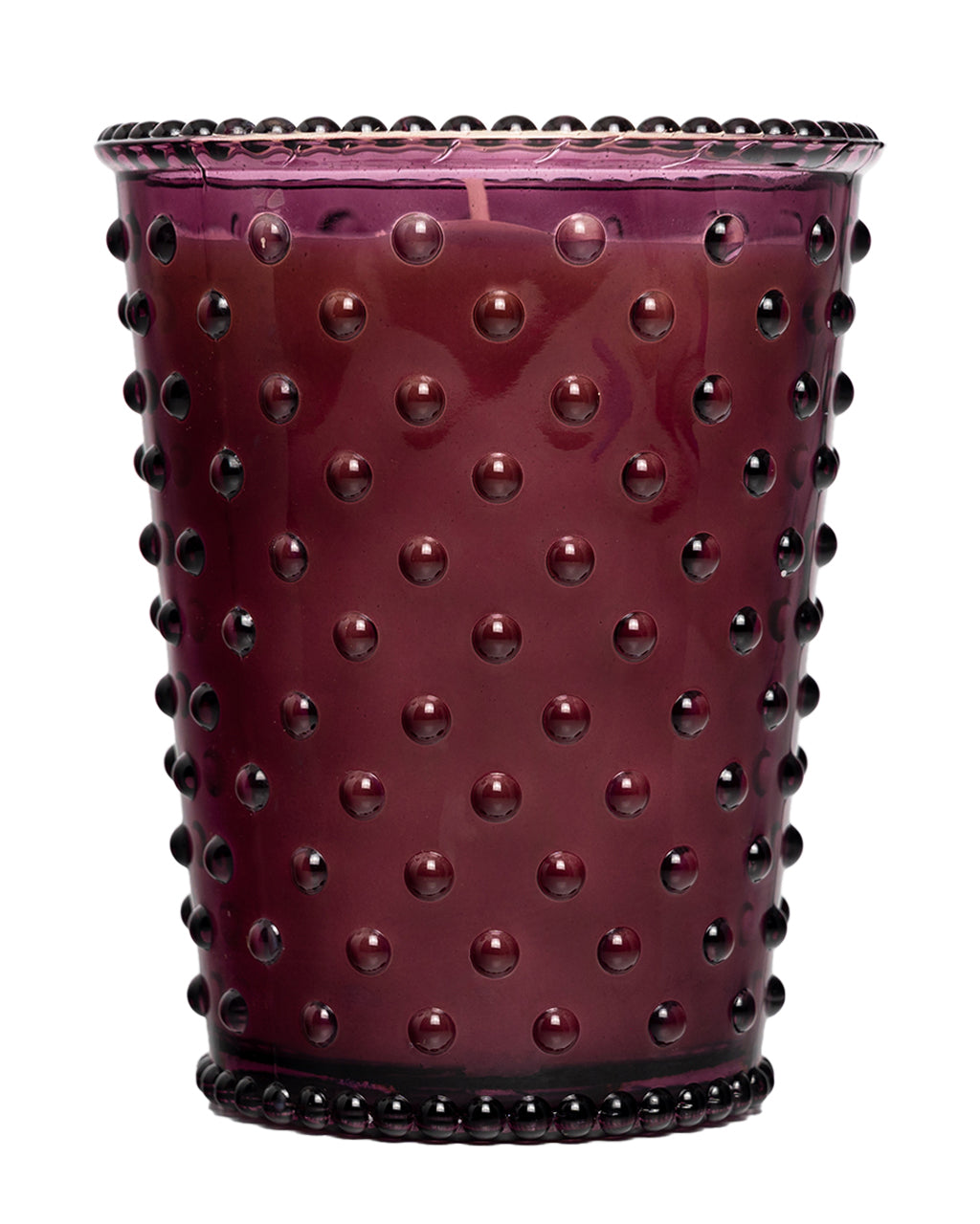 The Simpatico No. 98 Fig Hobnail Glass Candle by Simpatico features a purple glass holder with a hobnail texture and is filled with natural soy wax scented with fig.