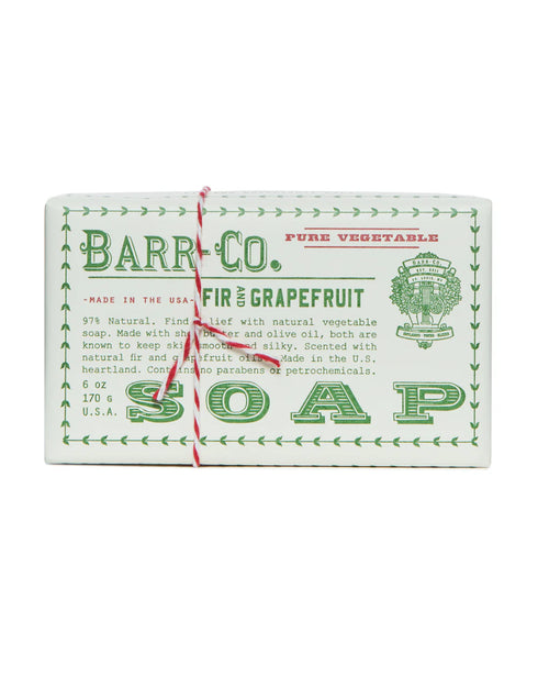 The Barr-Co. Fir Grapefruit Triple Milled Bar Soap is a rectangular artisanal soap in vintage-style white paper with green text, finished with red and white string, featuring nourishing olive oil for clean skincare.