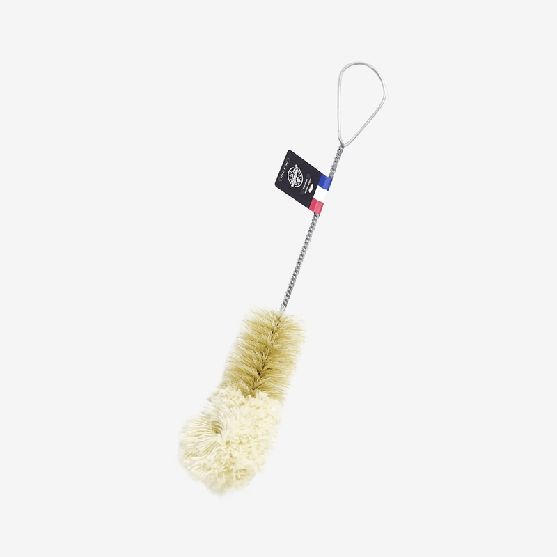 The Andrée Jardin Bistro Flute Cleaning Brush features natural bristles, a twisted metal handle with a loop, and a French flag ribbon tag—ideal for cleaning champagne flutes. Shown on a plain white background.
