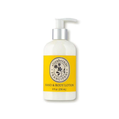 A white bottle of elizabeth W Botanist's Scent Lab Frangipani Hand & Body Lotion with a pump dispenser. The yellow label with black text and a floral emblem promises long-lasting hydration with a tropical flowers scent, containing 8 fl oz (236 mL) of product.