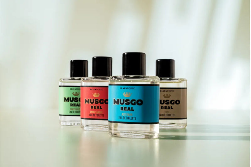 The Claus Porto Musgo Real Gift Set Hands Up Mini EDTCla by Claus Porto 1887 features four mini bottles, each with a different colored label—green, red, blue, and beige—arranged in a row, ideal for men’s fragrance gifting.