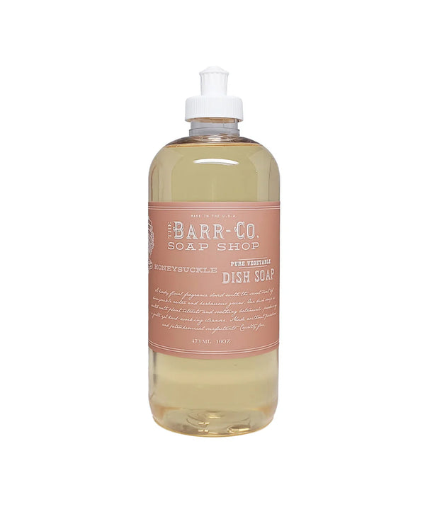 A clear bottle of Barr-Co. Honeysuckle Dish Soap with a pink label and white flip-top cap is filled with light yellow liquid and offers a fresh floral scent, perfect for cleaning dishes.