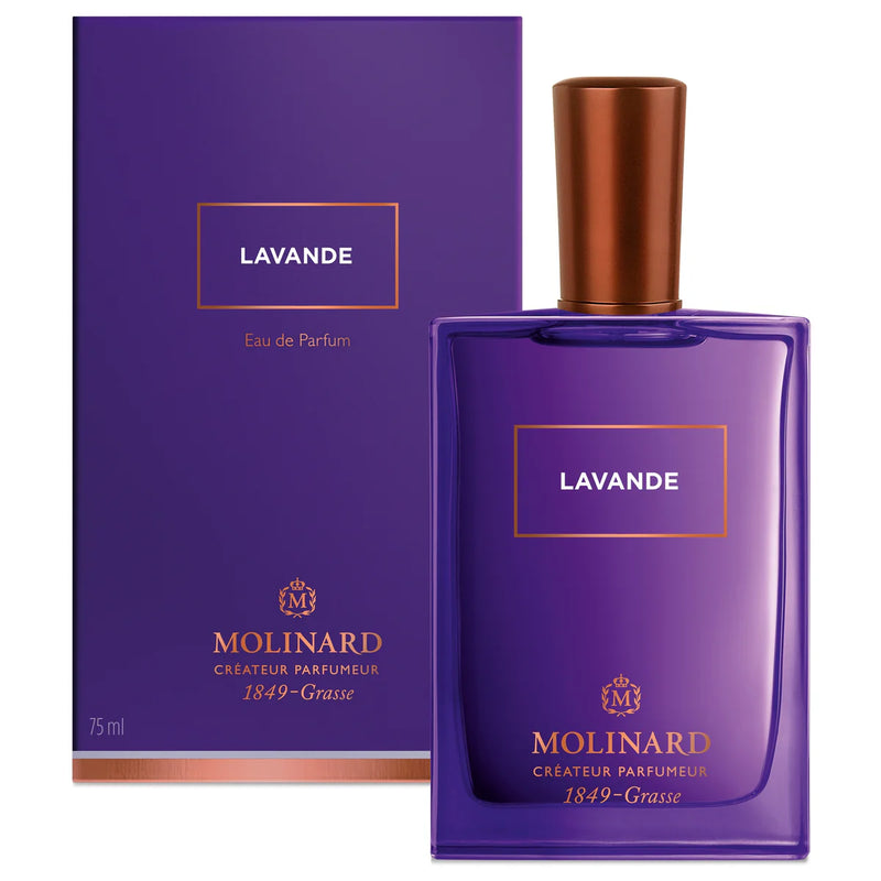 A purple Molinard Lavender Eau de Parfum bottle with a copper cap and gold text, plus a matching purple and gold box featuring the brand details. This Provence fragrance offers a floral woody scent.