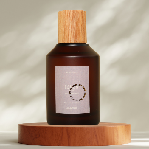 The ISULA parfums Fiore di Lavanda eau de toilette, in a brown glass bottle with a wooden cap, rests on a wooden platform. Its minimalist label and soft lighting evoke Corsican lavender fields and gentle shadows.