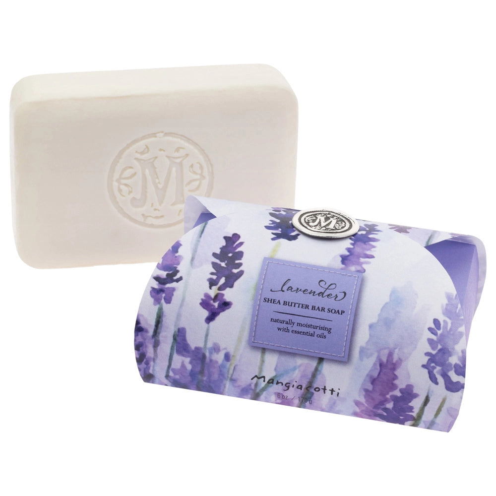 A white guest bar embossed with an "M" sits beside a floral box labeled "Mangiacotti Lavender Shea Butter Guest Bar Soap 6 oz.," crafted by Mangiacotti with natural ingredients for a soothing experience.