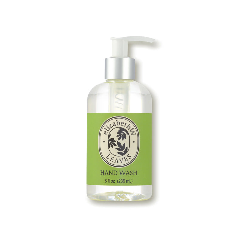 A clear pump bottle labeled "elizabeth W Botanist's Scent Lab Leaves Hand Wash" features a green label with black leaf accents. Contains 8 fl oz (236 mL) of liquid hand soap and pairs perfectly with elizabeth W Leaves Hand Cream.