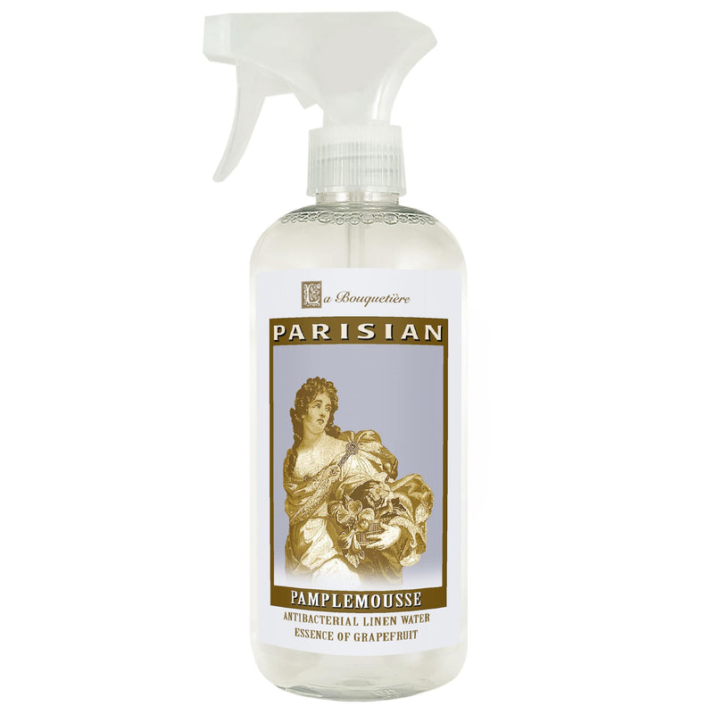 A bottle of La Bouquetiere Pamplemousse Vanille Antibacterial Linen Water with a spray nozzle, featuring a vintage illustration of a woman holding flowers, infused with natural fragrances.