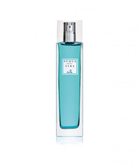 A tall, clear bottle with blue liquid, featuring a silver spray nozzle, labeled "Acqua dell'Elba Mare Room Spray" by Acqua dell'Elba, infused with lemon and marine algae scents. It is set against a plain white background.