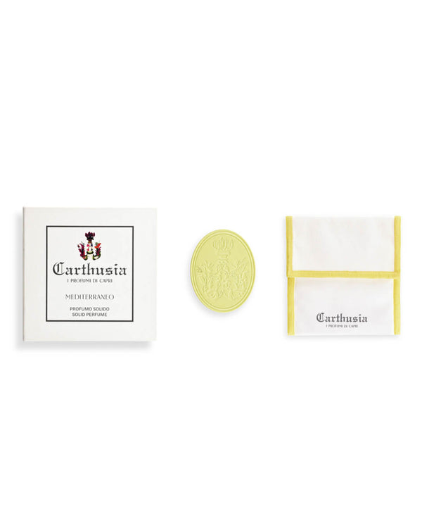 The Carthusia I Profumi di Capri Mediterraneo Solid Perfume set includes a white box with the brand logo, a round yellow perfume with fresh lemon leaf notes, and a white pouch trimmed in yellow featuring the Carthusia logo.