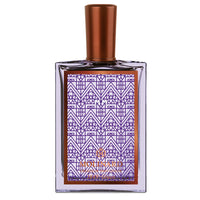 Molinard MM Eau de Parfum by Molinard comes in a clear glass bottle with a bronze cap and a label featuring geometric purple and bronze Art Deco patterns, illustrating the elegance of this woody amber fragrance.