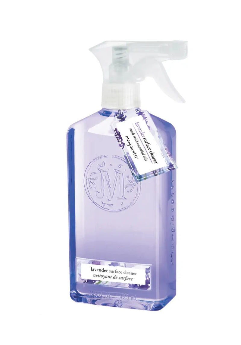 A transparent spray bottle containing Mangiacotti Lavender Surface Cleaner, labeled in English and French, with a detailed embossed Mangiacotti logo and a hanging descriptive tag.