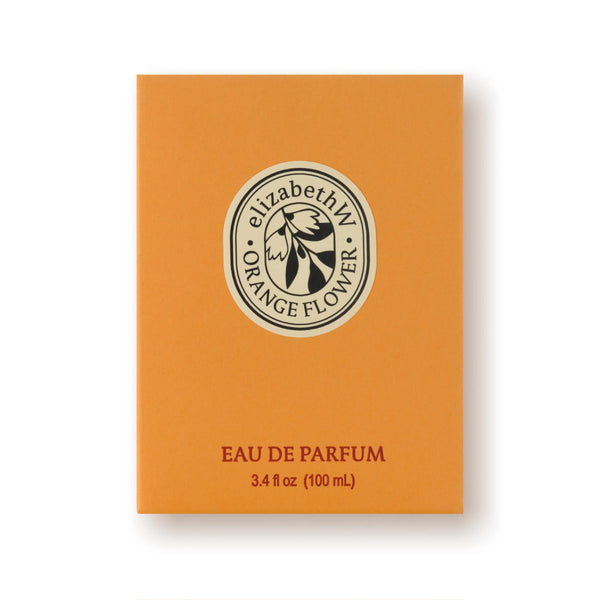 An orange rectangular box labeled “elizabeth W Orange Flower” displays the flower logo above “EAU DE PARFUM 3.4 fl oz (100 mL)”. The white background highlights this bright, floral Elizabeth W Orange Flower Eau de Parfum.