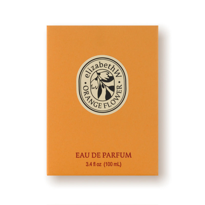 An orange rectangular box labeled “elizabeth W Orange Flower” displays the flower logo above “EAU DE PARFUM 3.4 fl oz (100 mL)”. The white background highlights this bright, floral Elizabeth W Orange Flower Eau de Parfum.