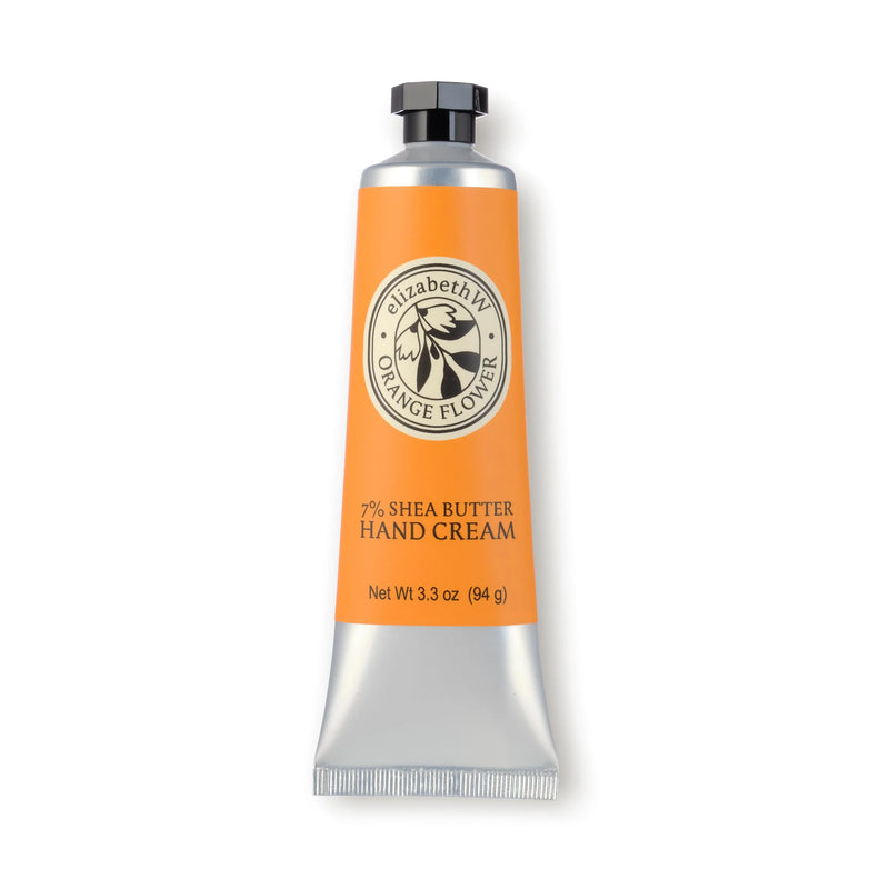 A silver and orange tube of elizabeth W Orange Flower Hand Cream, 3.3 oz (94 g), featuring 7% Shea Butter, a black screw cap, and a flower-themed logo on the front.