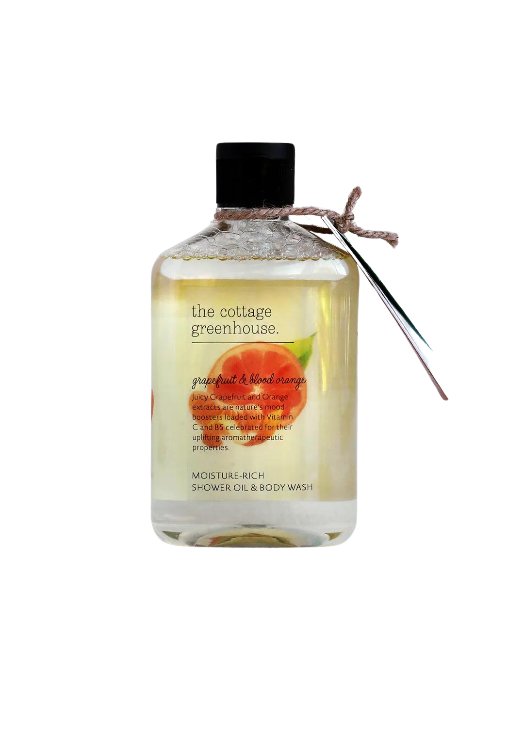 A transparent bottle of Margot Elena's The Cottage Greenhouse Grapefruit & Blood Orange Body Wash, labeled grapefruit and blood orange, with moisture-rich content, tied with a twine at the neck, on a white