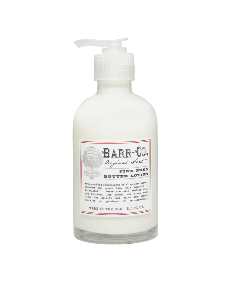 Clear bottle of Barr-Co. Original Scent Shea Butter Lotion with a pump dispenser, featuring botanicals, isolated on a white background. The label includes details of the scent and ingredients.