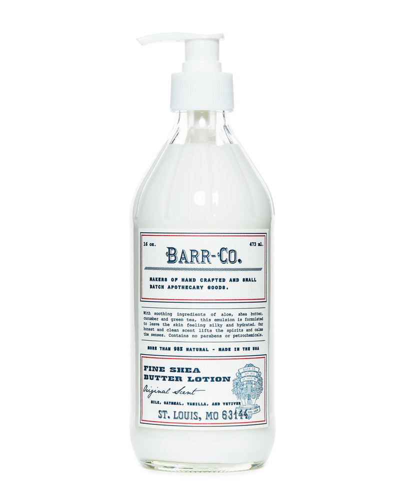 A transparent glass bottle equipped with a pump dispenser and labeled "Barr-Co." contains the Barr-Co. Original Scent Shea Butter Lotion - 20 oz, enriched with natural plant extracts. The label highlights words such as "handcrafted," "made in the USA," and "St. Louis, MO 63144," alongside small decorative elements, underscoring its nourishing qualities.