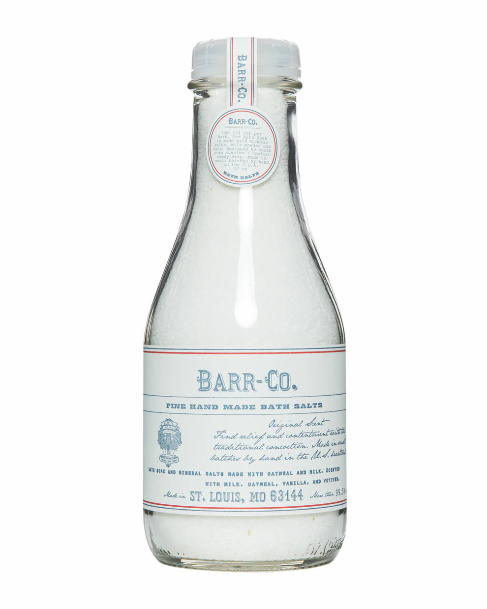 A clear glass bottle with a white and blue label and matching cap, labeled "Barr-Co. Original Scent Bath Soak Salt," contains white mineral bath salts made by Barr-Co. The label features product details and origin information.
