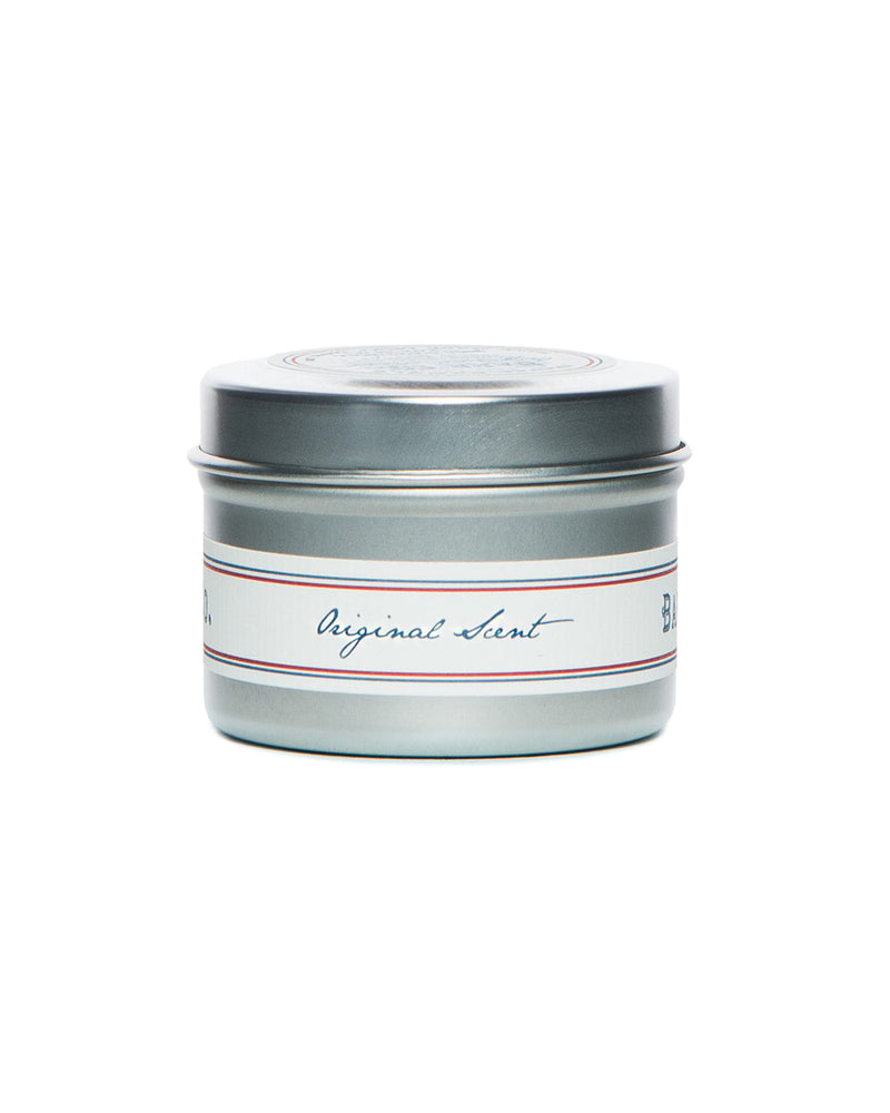 The Barr-Co. Original Scent Travel Candle is a small silver tin with a screw-on lid, elegantly labeled in cursive. Made from soy wax, it offers a soothing scent, perfect for on-the-go relaxation.