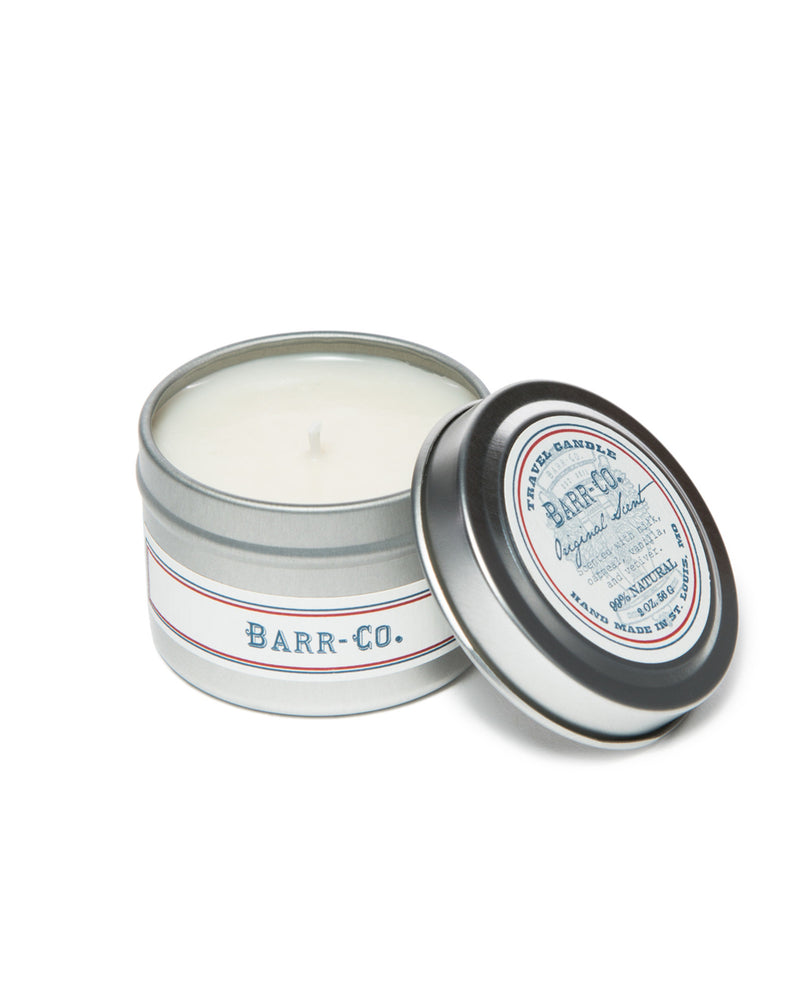 The Barr-Co. Original Scent Travel Candle features a sleek tin container with white soy wax and elegant blue and red accents. The lid leans slightly, showcasing the label on top for a charming display.