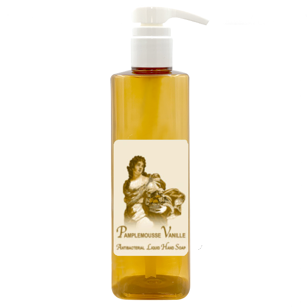 A clear amber bottle with a white pump dispenser is labeled "La Bouquetiere La Bouquetiere Pamplemousse (Grapefruit) Vanilla Antibacterial Liquid Hand Soap." The label features an illustration of a person holding a bowl of fruit.