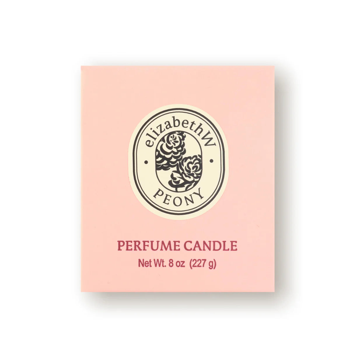 The pink box of the elizabeth W Botanist's Scent Lab Peony Candle showcases a floral logo and is decorated with the label "elizabethW PEONY." Made from renewable soy wax, this elegant candle weighs 8 oz (227 g), offering a delightful fragrance experience.