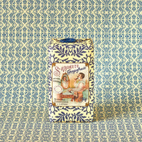 A bar of Claus Porto 1887 Classico Barbear Grapefruit Fig Soap, wrapped in blue and white patterned paper, stands upright against a coordinating background. The label shows vintage art of a woman by a mirror and reads "Sabonete Grapefruit Fig Scent.