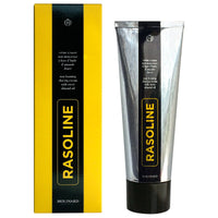 A metallic tube and yellow-black box of Molinard Rasoline Shaving Cream by Molinard, a heritage formula with sweet almond oil for a waterless shave. "RASOLINE" appears vertically in yellow on both the tube and box.