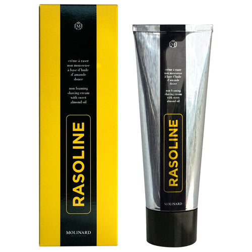 A metallic tube and yellow-black box of Molinard Rasoline Shaving Cream by Molinard, a heritage formula with sweet almond oil for a waterless shave. "RASOLINE" appears vertically in yellow on both the tube and box.