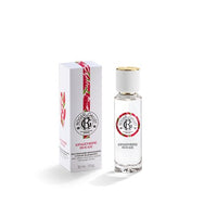 A 1oz Roger & Gallet Red Ginger Wellbeing Water bottle with a gold cap stands next to its white box decorated with red and green leaf designs. The clear glass displays the brand’s label, highlighting this refreshing scent.