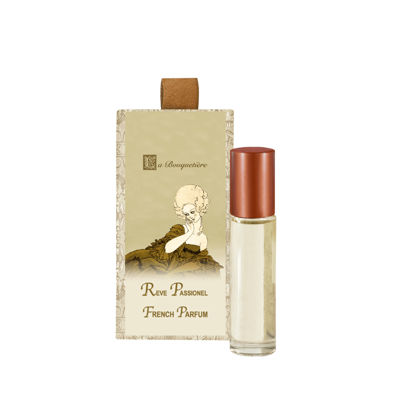 A La Bouquetiere Reve Passionnel Perfume Roller bottle alongside its packaging, which features a vintage-style illustration of a cherub on a beige background.