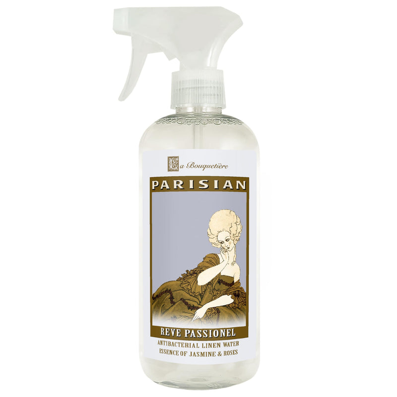A spray bottle of "La Bouquetiere Reve Passionel Antibacterial Linen Water" with an antique-style label featuring a vintage illustration of a woman and text that reads "reve passionnel, essence of jasmine &.